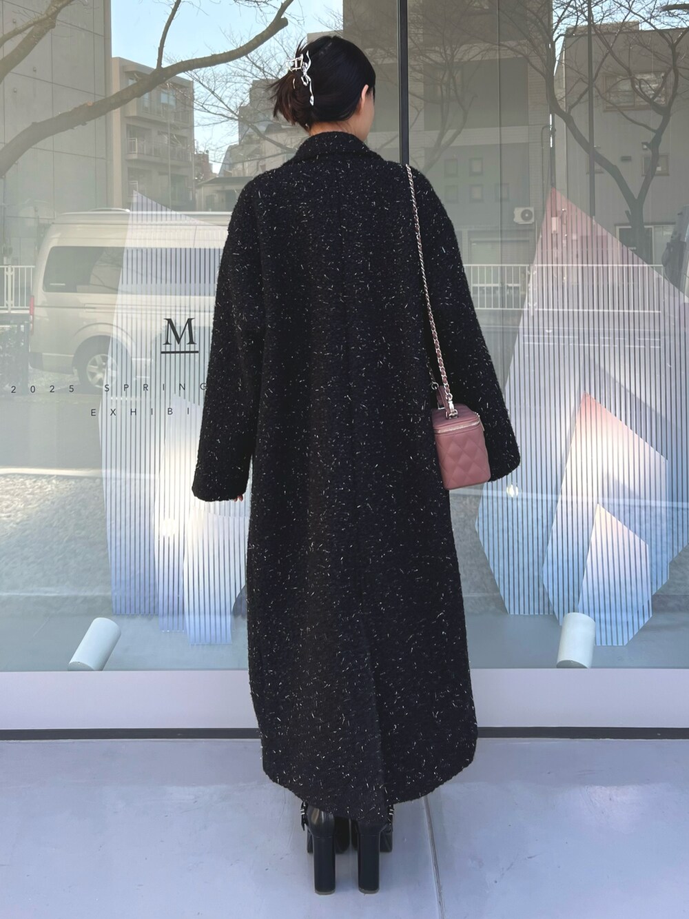 ピンク系のハンドバッグ、ブラック系のチェスターコート、ブラック系のブーツを着用したレディースの冬コーディネートの6枚目の写真