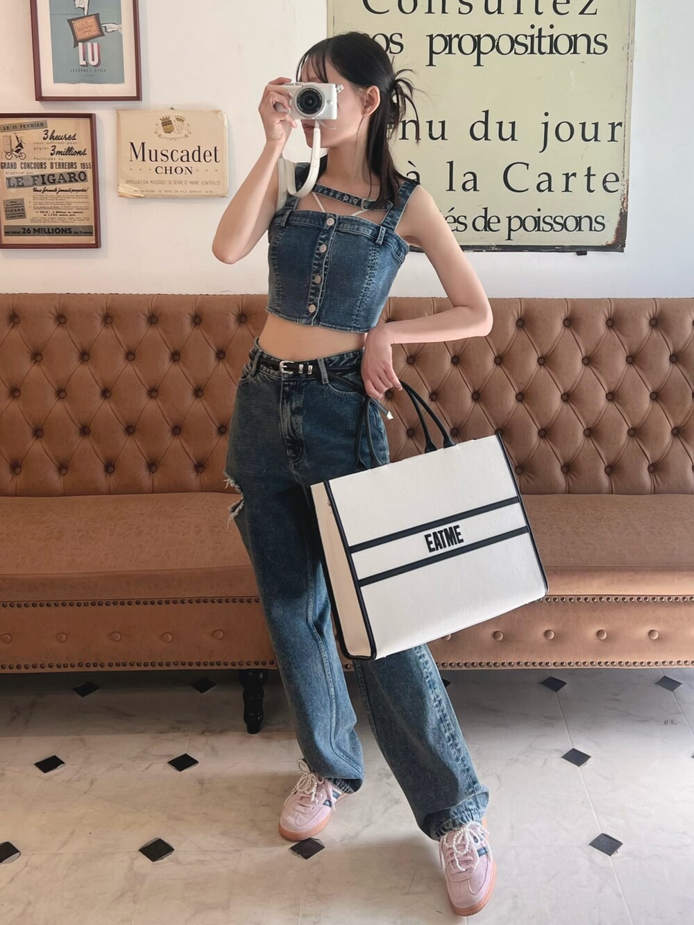 ブルー系のキャミソール、ホワイト系のトートバッグ、ブルー系のデニムパンツを着用したレディースの春コーディネートの2枚目の写真