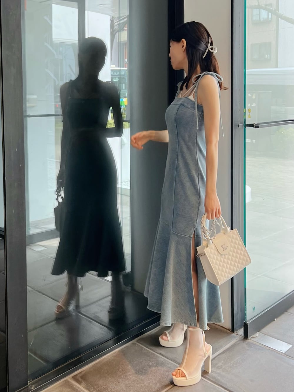 ブルー系のワンピース、ホワイト系のサンダル、ホワイト系のハンドバッグを着用したレディースの春コーディネートの3枚目の写真