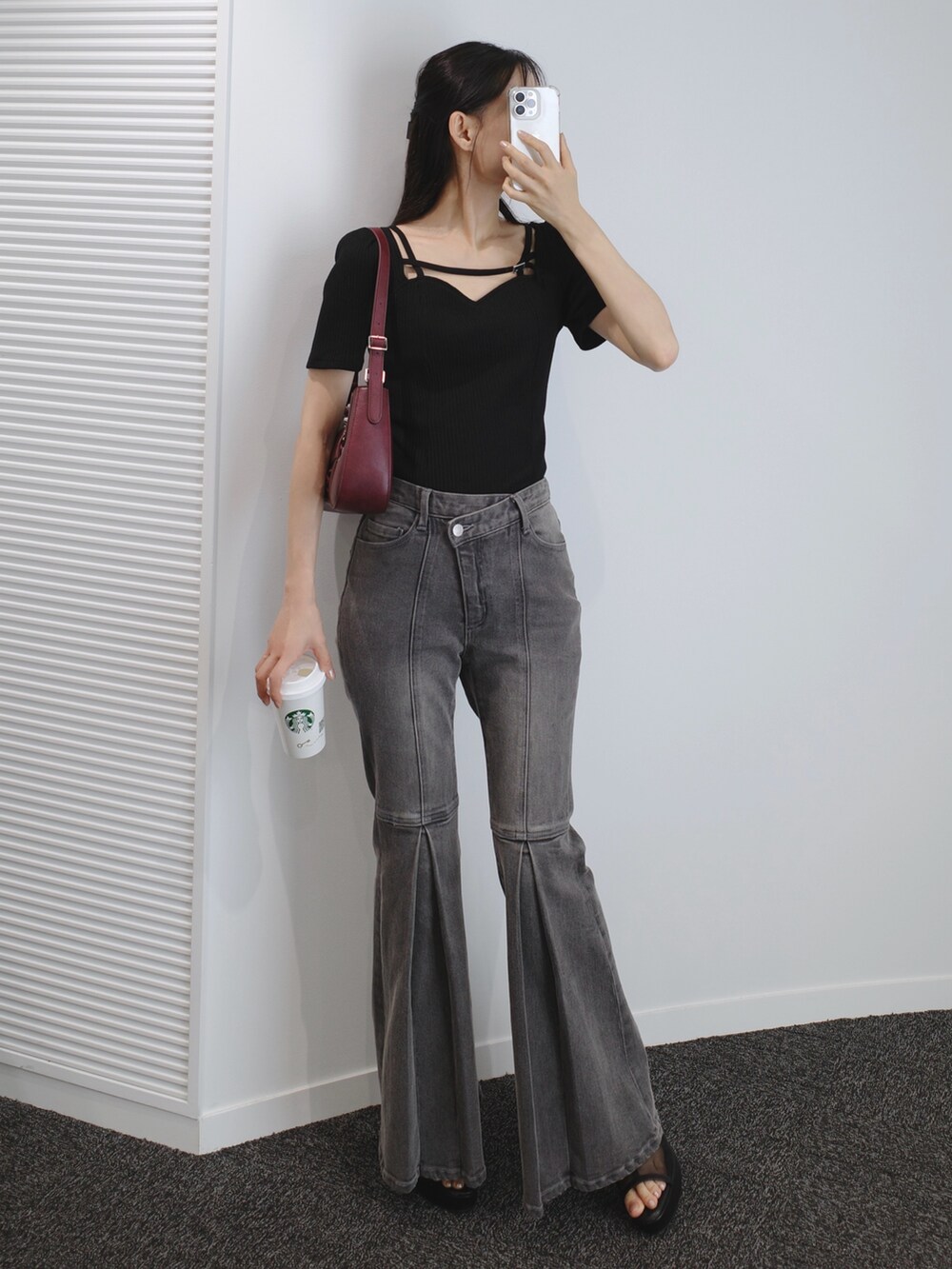 ブラック系のデニムパンツ、ブラック系のサンダル、レッド系のショルダーバッグを着用したレディースの夏コーディネートの4枚目の写真