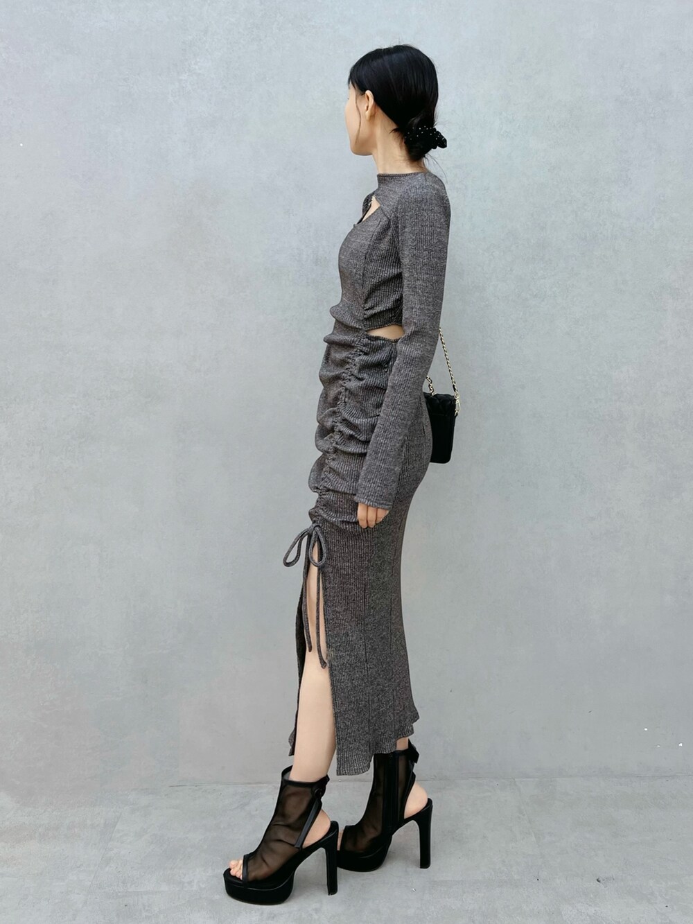 グレー系のワンピース、ブラック系のサンダル、ブラック系のショルダーバッグを着用したレディースの秋コーディネートの2枚目の写真