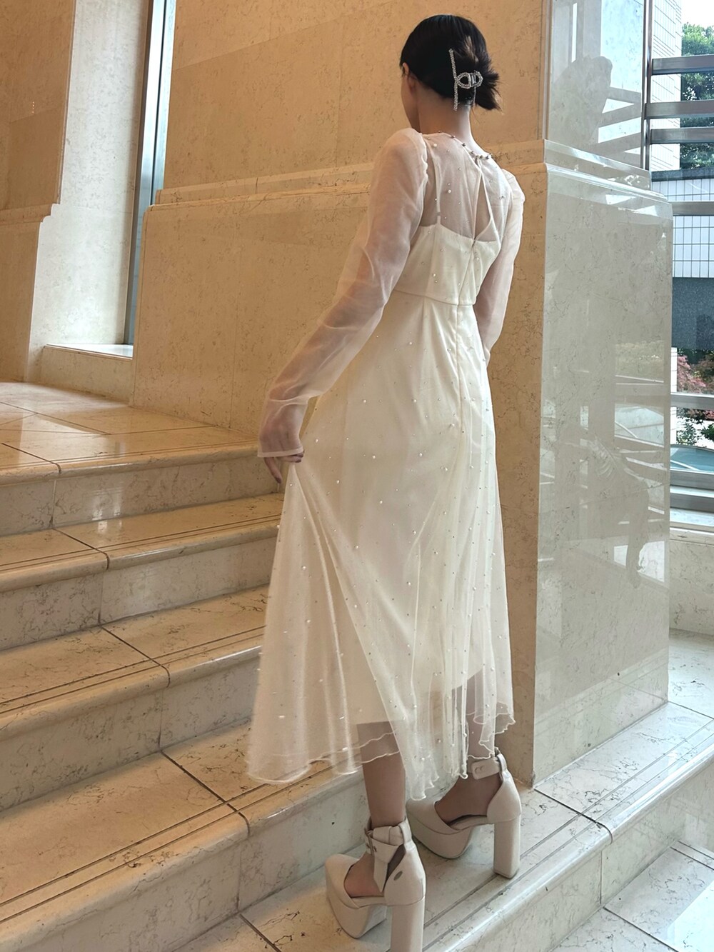 ホワイト系のワンピース、ホワイト系のパンプスを着用したレディースの冬コーディネートの3枚目の写真