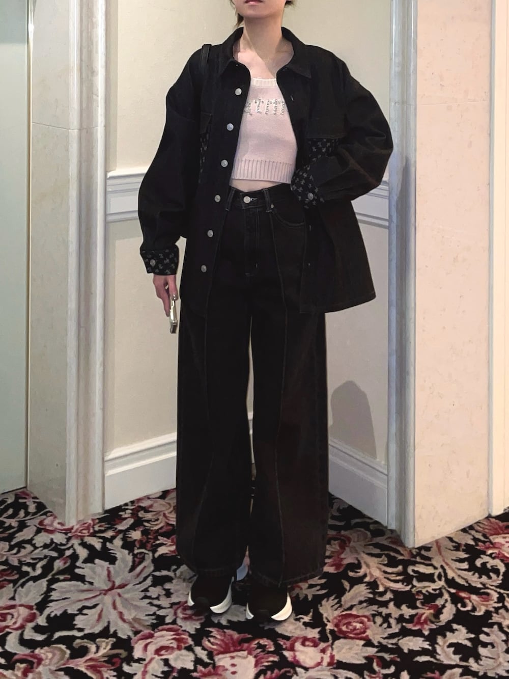 ブラック系のデニムジャケット、ブラック系のデニムパンツ、ピンク系のニット/セーターを着用したレディースの冬コーディネートの5枚目の写真