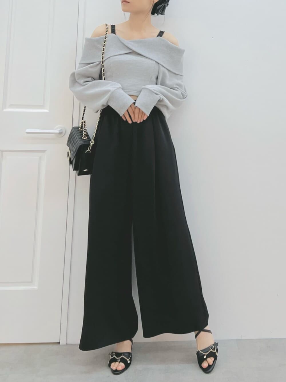 ブラック系のショルダーバッグ、ブラック系のサンダル、グレー系のTシャツ/カットソーを着用したレディースの夏コーディネートの2枚目の写真