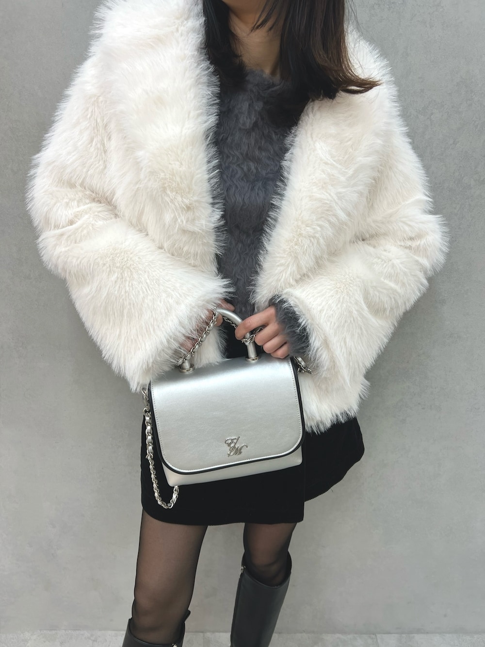 ホワイト系のその他アウター、グレー系のニット/セーター、シルバー系のショルダーバッグを着用したレディースの冬コーディネートの7枚目の写真