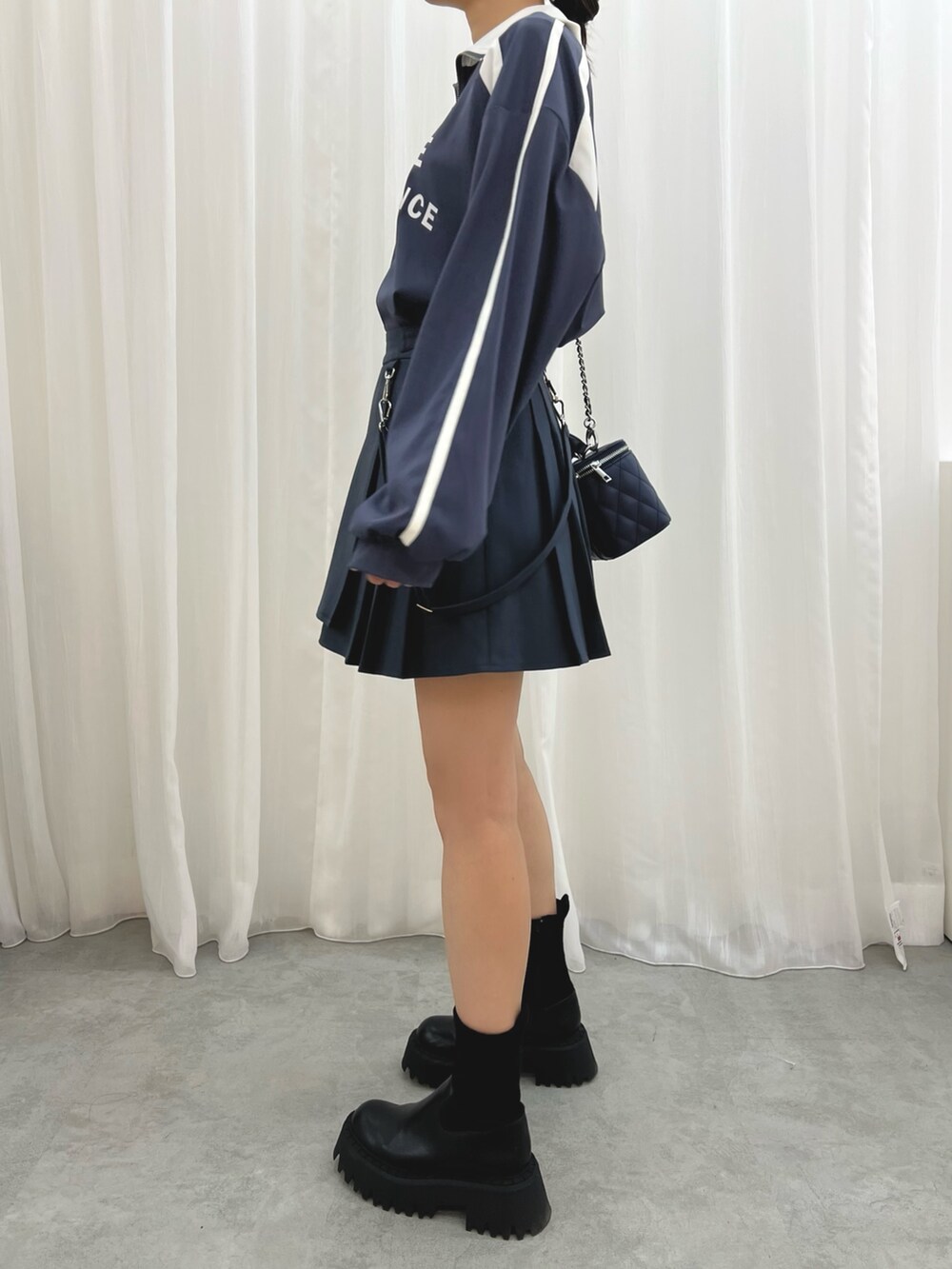 ブルー系のハンドバッグ、ブルー系のスカート、ブルー系のTシャツ/カットソーを着用したレディースの冬コーディネートの5枚目の写真