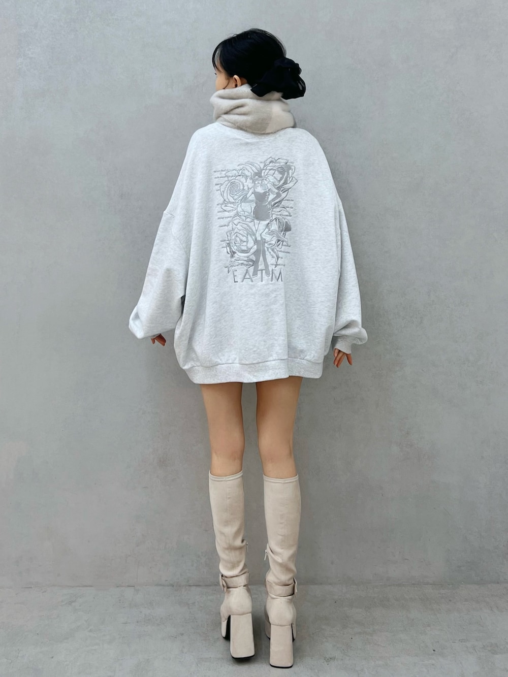 グレー系のスウェット、ホワイト系のブーツ、グレー系のマフラーを着用したレディースの秋コーディネートの4枚目の写真