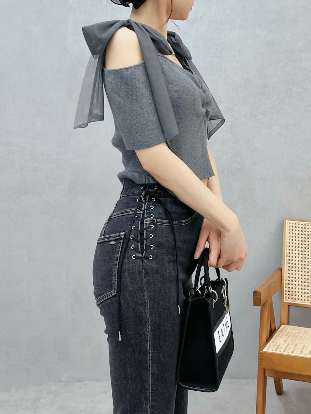 ブルー系のデニムパンツ、ブラック系のショルダーバッグ、グレー系のTシャツ/カットソーを着用したレディースの春コーディネートの6枚目の写真