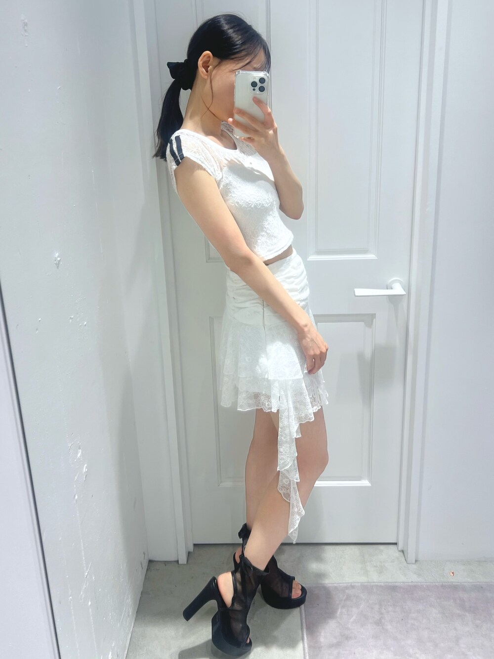 ホワイト系のスカート、ホワイト系のTシャツ/カットソー、ブラック系のサンダルを着用したレディースの春コーディネートの3枚目の写真