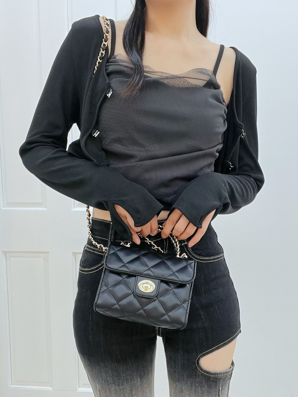 その他のデニムパンツ、ブラック系のブーツ、ブラック系のハンドバッグを着用したレディースの冬コーディネートの7枚目の写真