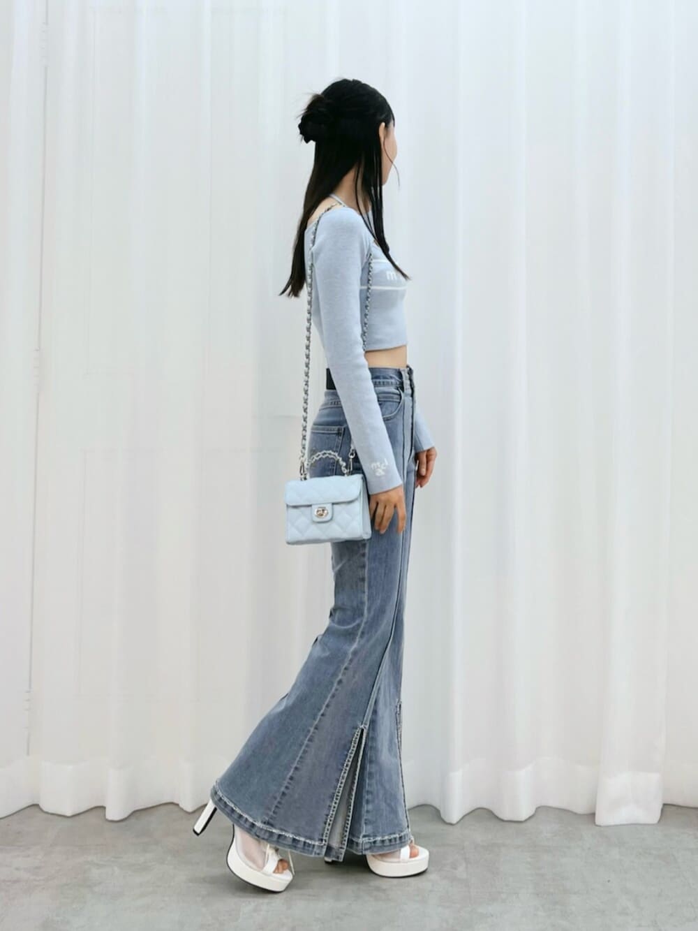 ホワイト系のブーツ、ブルー系のニット/セーター、ブルー系のデニムパンツを着用したレディースの冬コーディネートの2枚目の写真