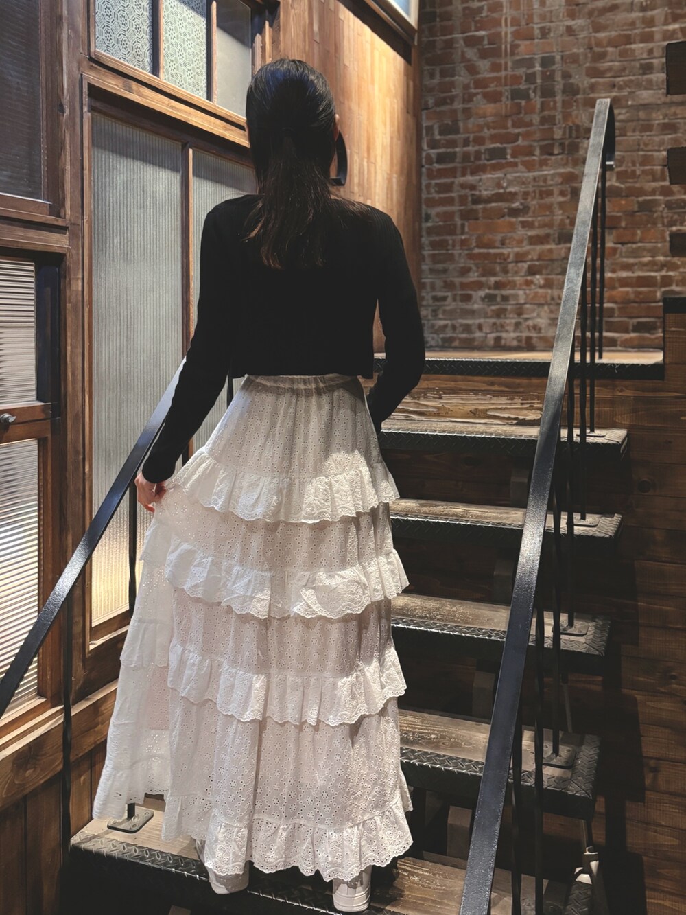 ホワイト系のスカート、ブラック系のTシャツ/カットソーを着用したレディースの夏コーディネートの3枚目の写真