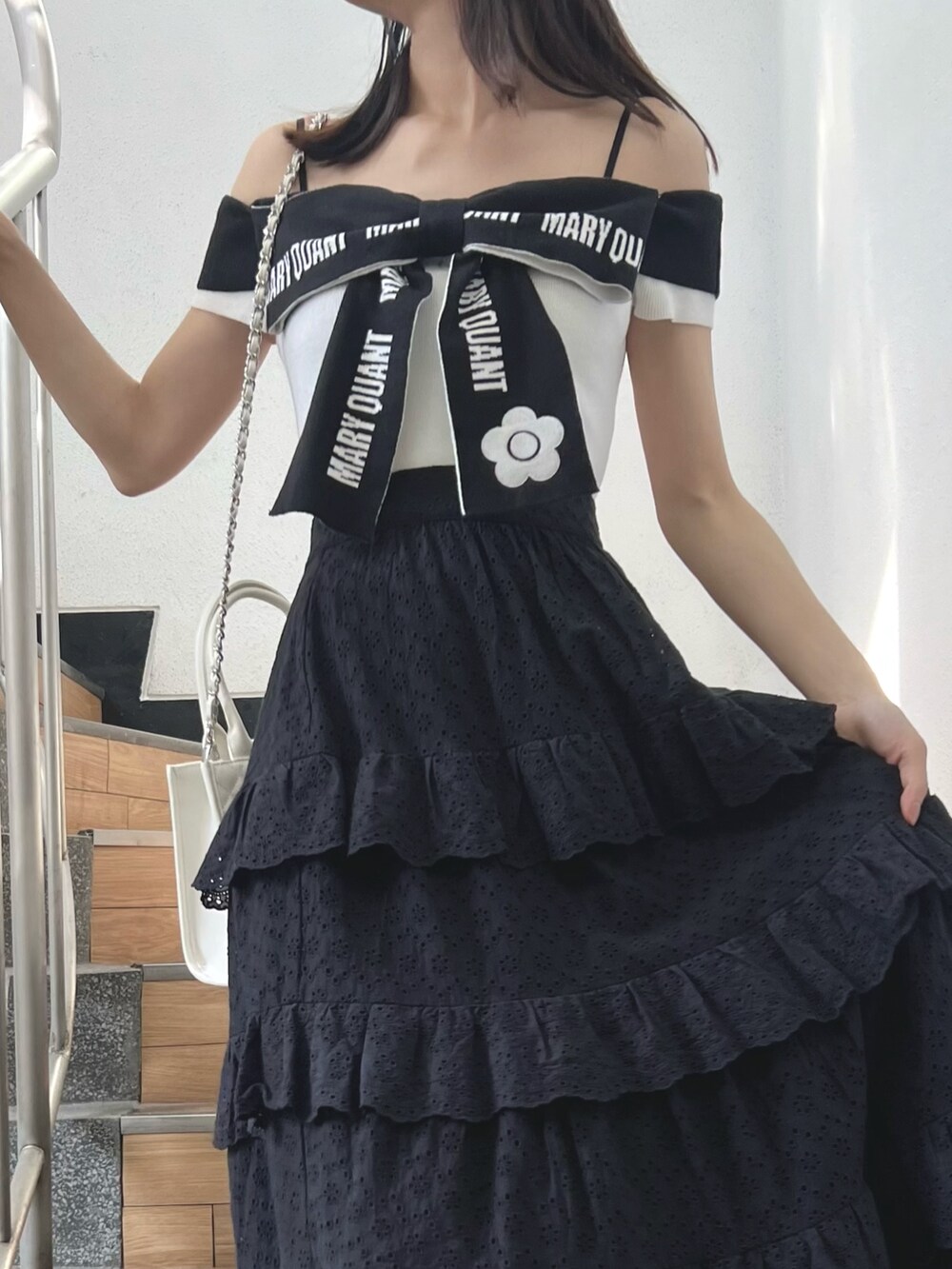 ブラック系のスカート、ホワイト系のワンピース、ホワイト系のサンダルを着用したレディースの春コーディネートの5枚目の写真