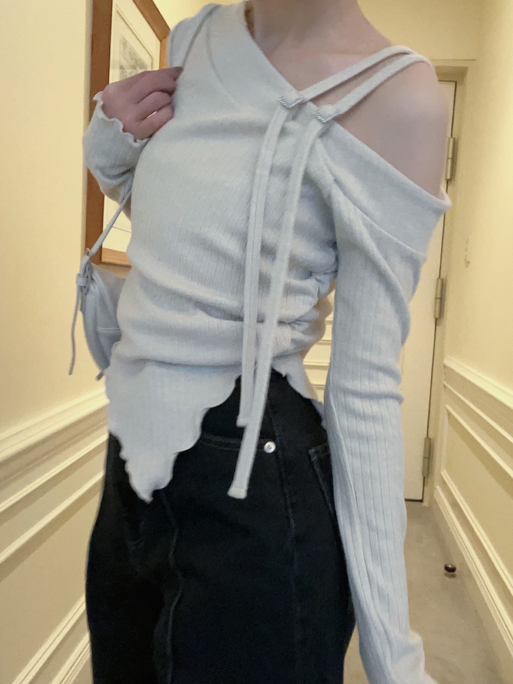 ブラック系のデニムパンツ、ホワイト系のショルダーバッグ、ホワイト系のTシャツ/カットソーを着用したレディースの冬コーディネートの3枚目の写真