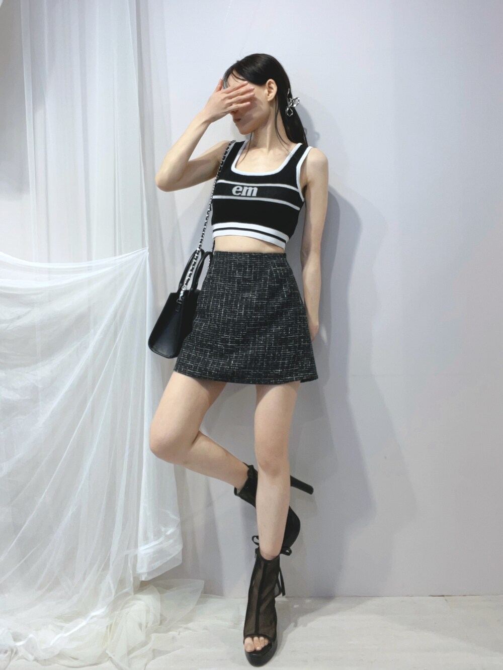 ブラック系のタンクトップ、ブラック系のハンドバッグ、ブラック系のサンダルを着用したレディースの春コーディネートの2枚目の写真