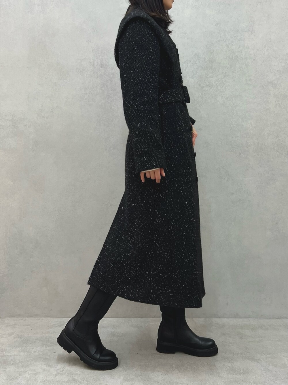 ブラック系のチェスターコート、レッド系のショルダーバッグ、ホワイト系のニット/セーターを着用したレディースの冬コーディネートの3枚目の写真