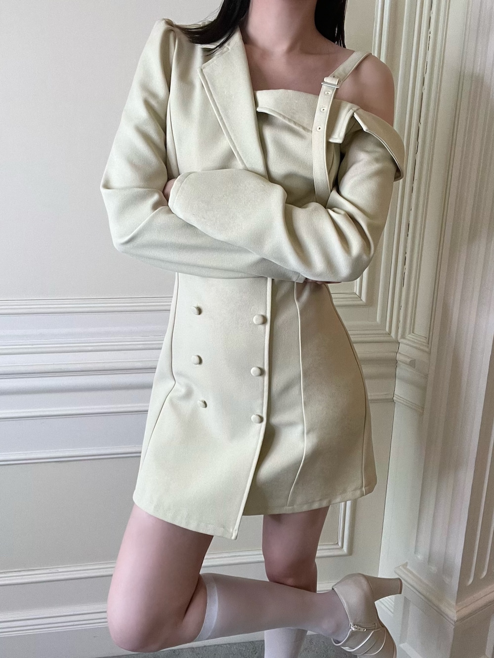 イエロー系のワンピース、ホワイト系のブーツを着用したレディースの冬コーディネートの3枚目の写真