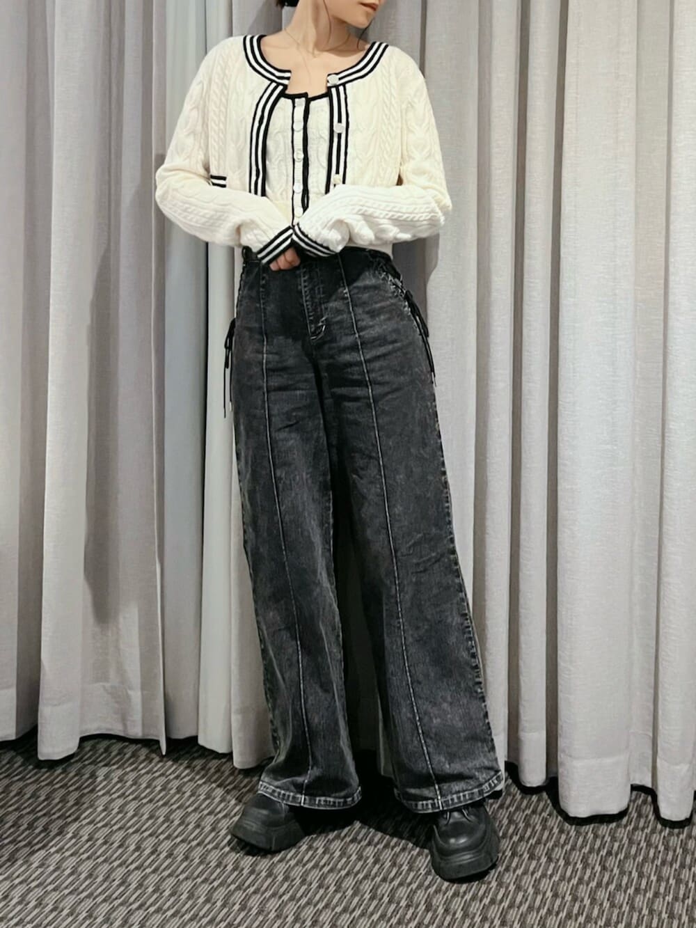 ホワイト系のニット/セーター、ブラック系のデニムパンツ、ゴールド系のネックレスを着用したレディースの秋コーディネートの5枚目の写真