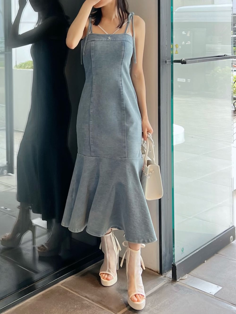 ブルー系のワンピース、ホワイト系のサンダル、ホワイト系のハンドバッグを着用したレディースの春コーディネートの2枚目の写真