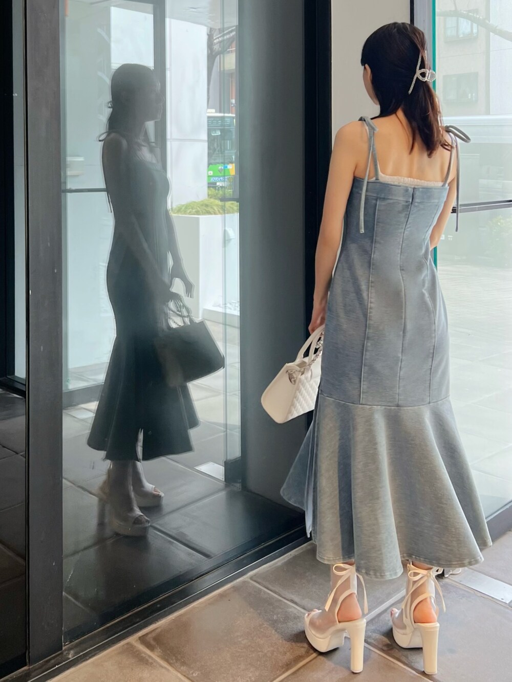 ブルー系のワンピース、ホワイト系のサンダル、ホワイト系のハンドバッグを着用したレディースの春コーディネートの5枚目の写真