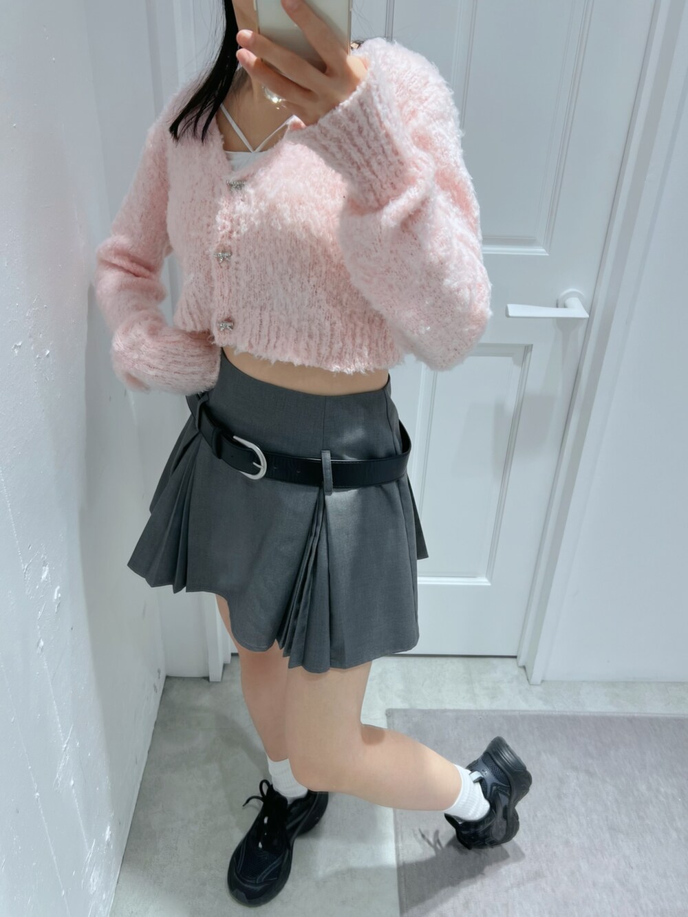 グレー系のスカート、ピンク系のカーディガン/ボレロ、ホワイト系のその他アンダーウェア/インナーを着用したレディースの春コーディネートの2枚目の写真