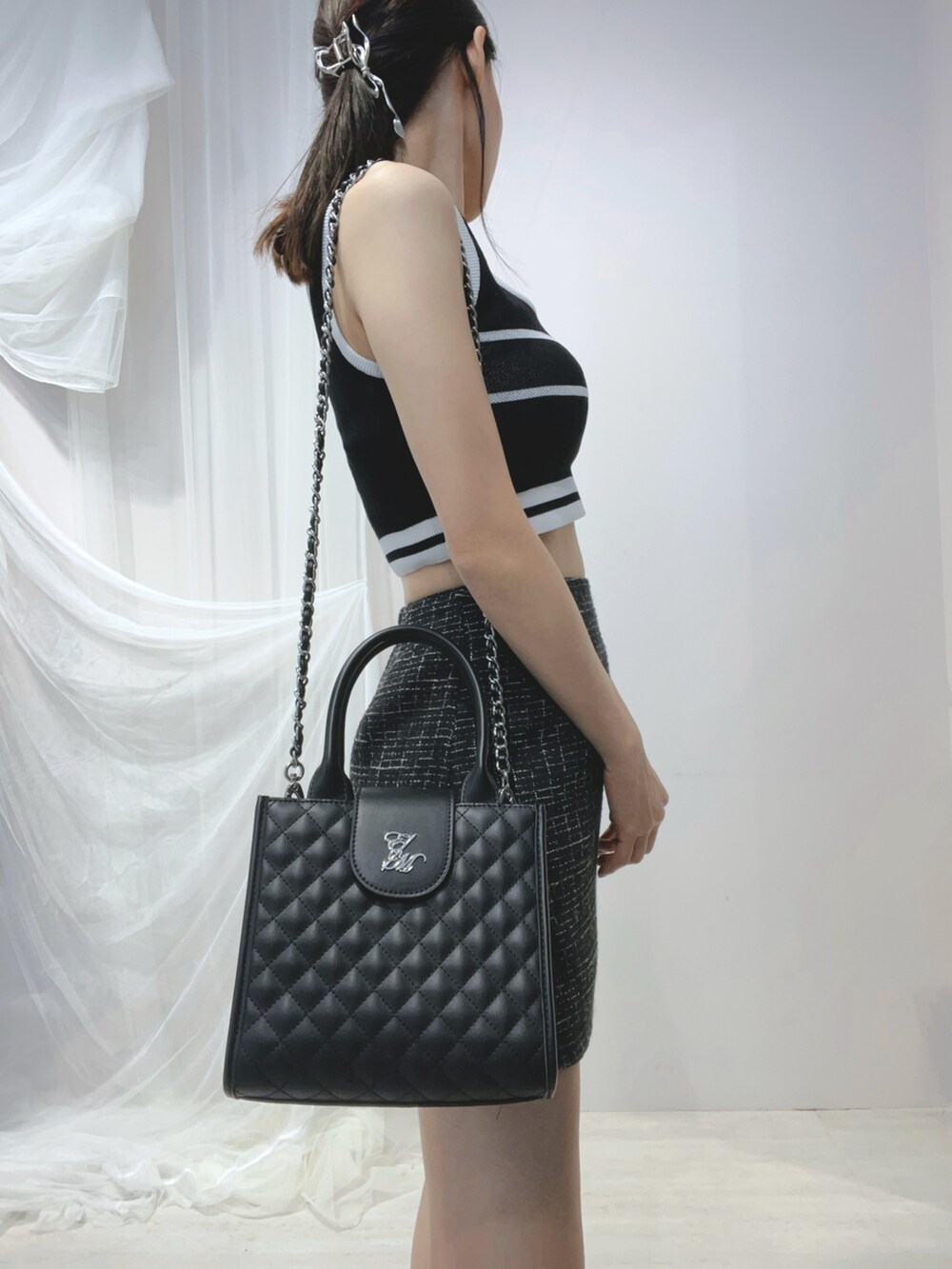 ブラック系のタンクトップ、ブラック系のハンドバッグ、ブラック系のサンダルを着用したレディースの春コーディネートの6枚目の写真