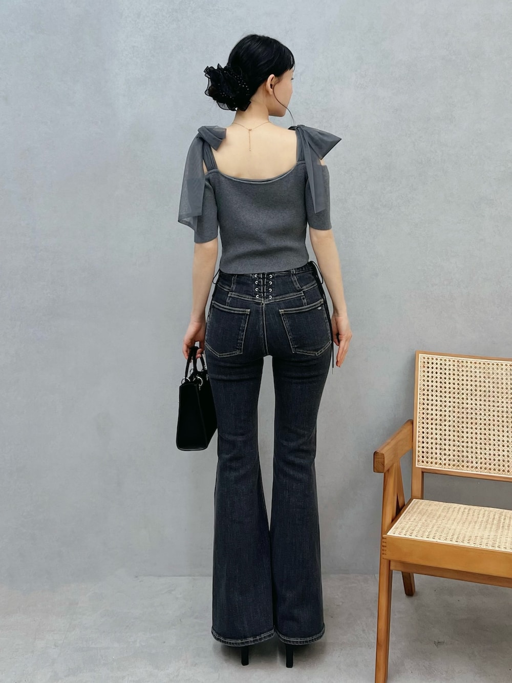 ブルー系のデニムパンツ、ブラック系のショルダーバッグ、グレー系のTシャツ/カットソーを着用したレディースの春コーディネートの3枚目の写真