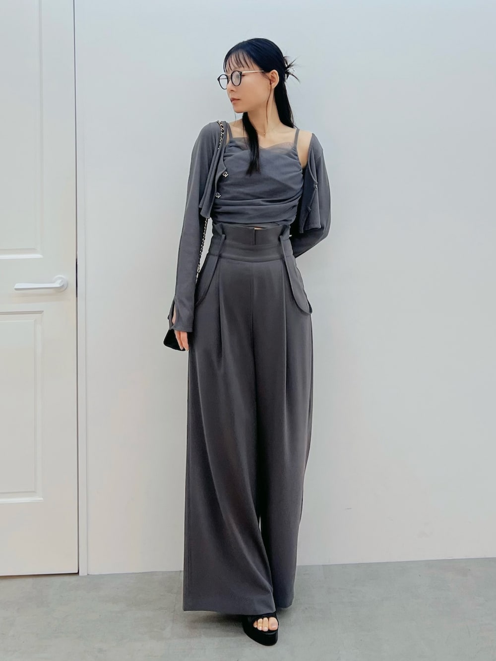 ブラック系のハンドバッグ、ブラック系のサンダル、グレー系のその他パンツを着用したレディースの春コーディネートの4枚目の写真