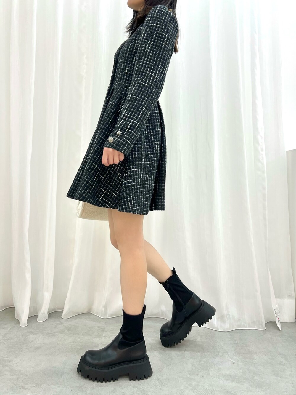 ブラック系のワンピース、ホワイト系のハンドバッグを着用したレディースの冬コーディネートの2枚目の写真