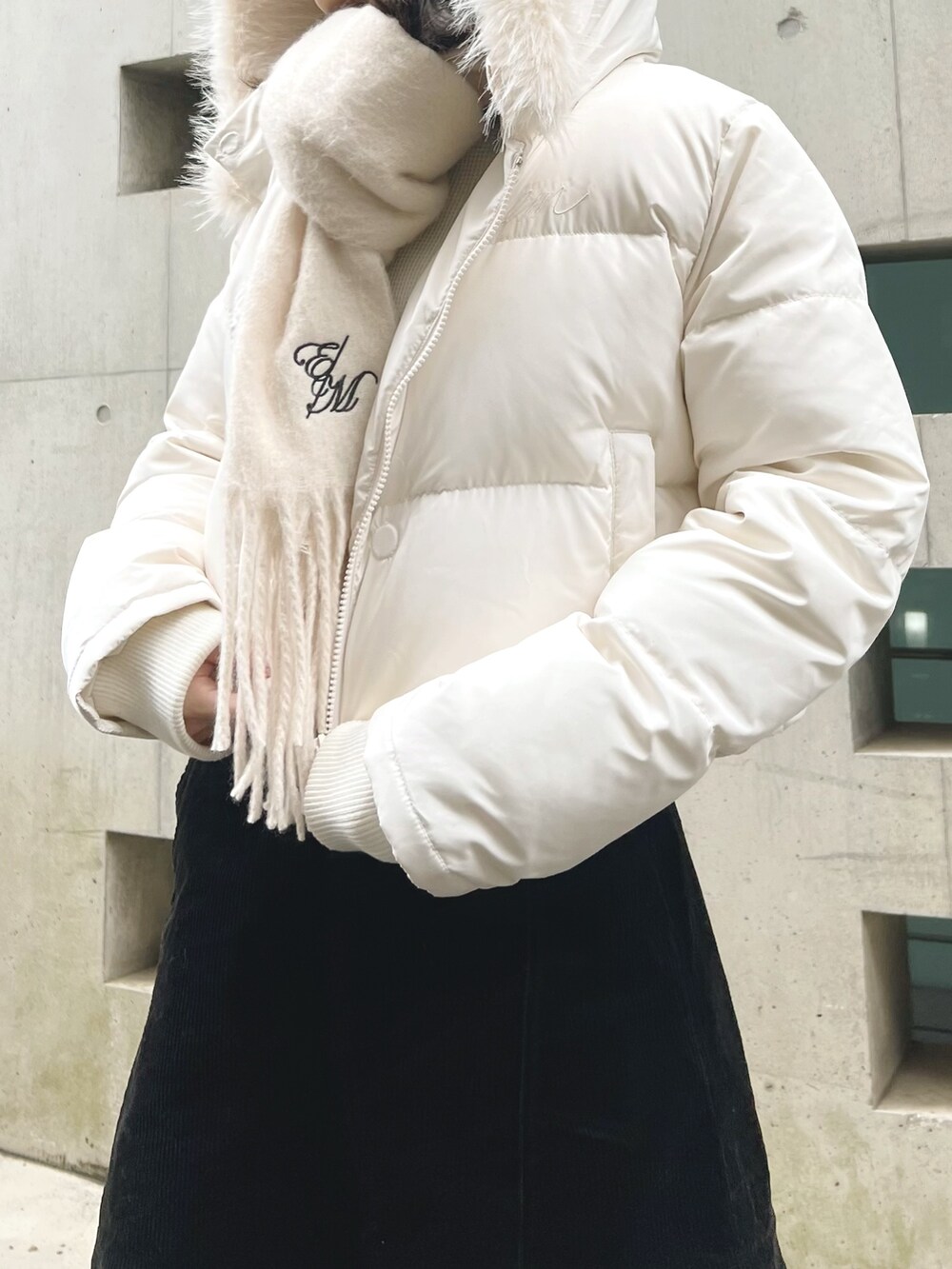 ホワイト系のブルゾン、ホワイト系のマフラーを着用したレディースの冬コーディネートの2枚目の写真