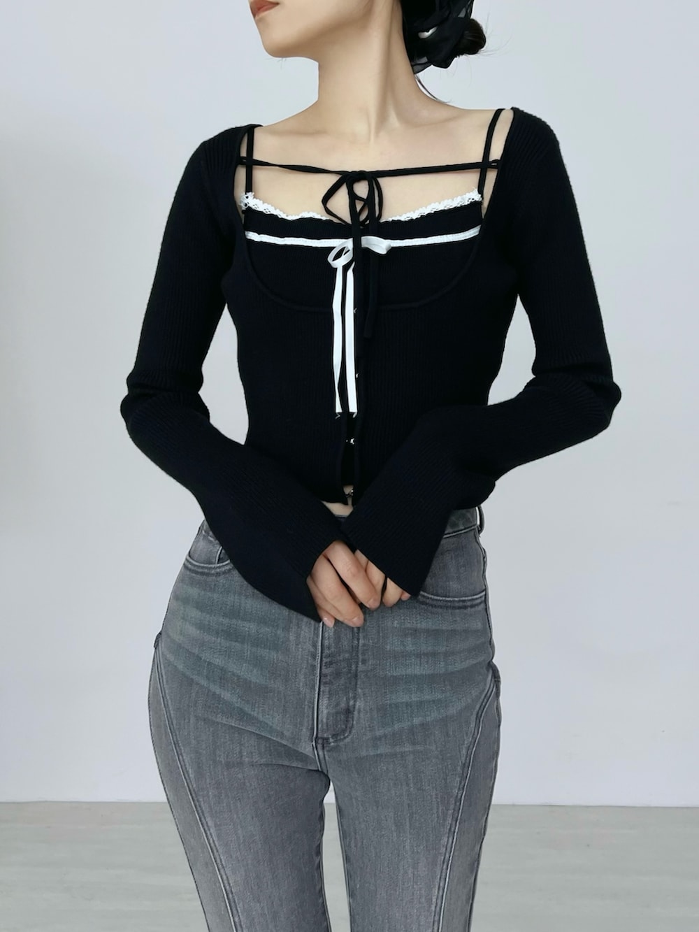 ブラック系のデニムパンツ、ブラック系のニット/セーター、ブラック系のブーツを着用したレディースの秋コーディネートの5枚目の写真