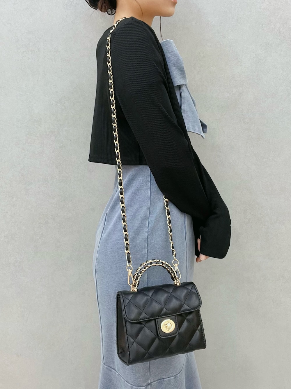 ブルー系のワンピース、ブラック系のTシャツ/カットソー、ブラック系のブーツを着用したレディースの春コーディネートの6枚目の写真