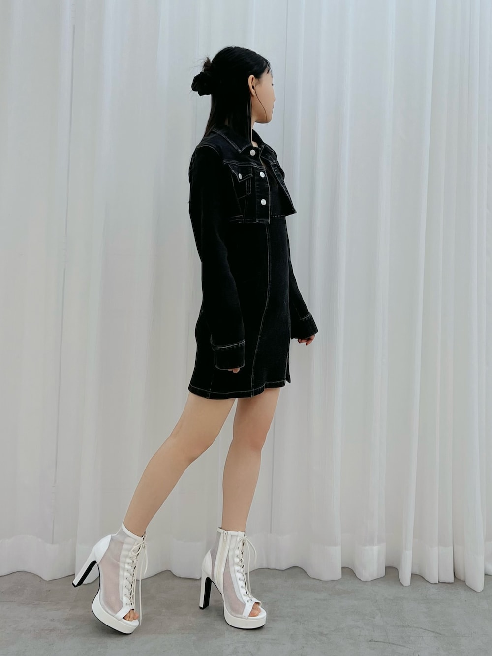 ブラック系のワンピース、ホワイト系のブーツを着用したレディースの冬コーディネートの2枚目の写真