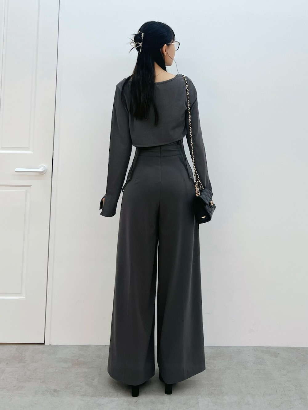 ブラック系のハンドバッグ、ブラック系のサンダル、グレー系のその他パンツを着用したレディースの春コーディネートの3枚目の写真