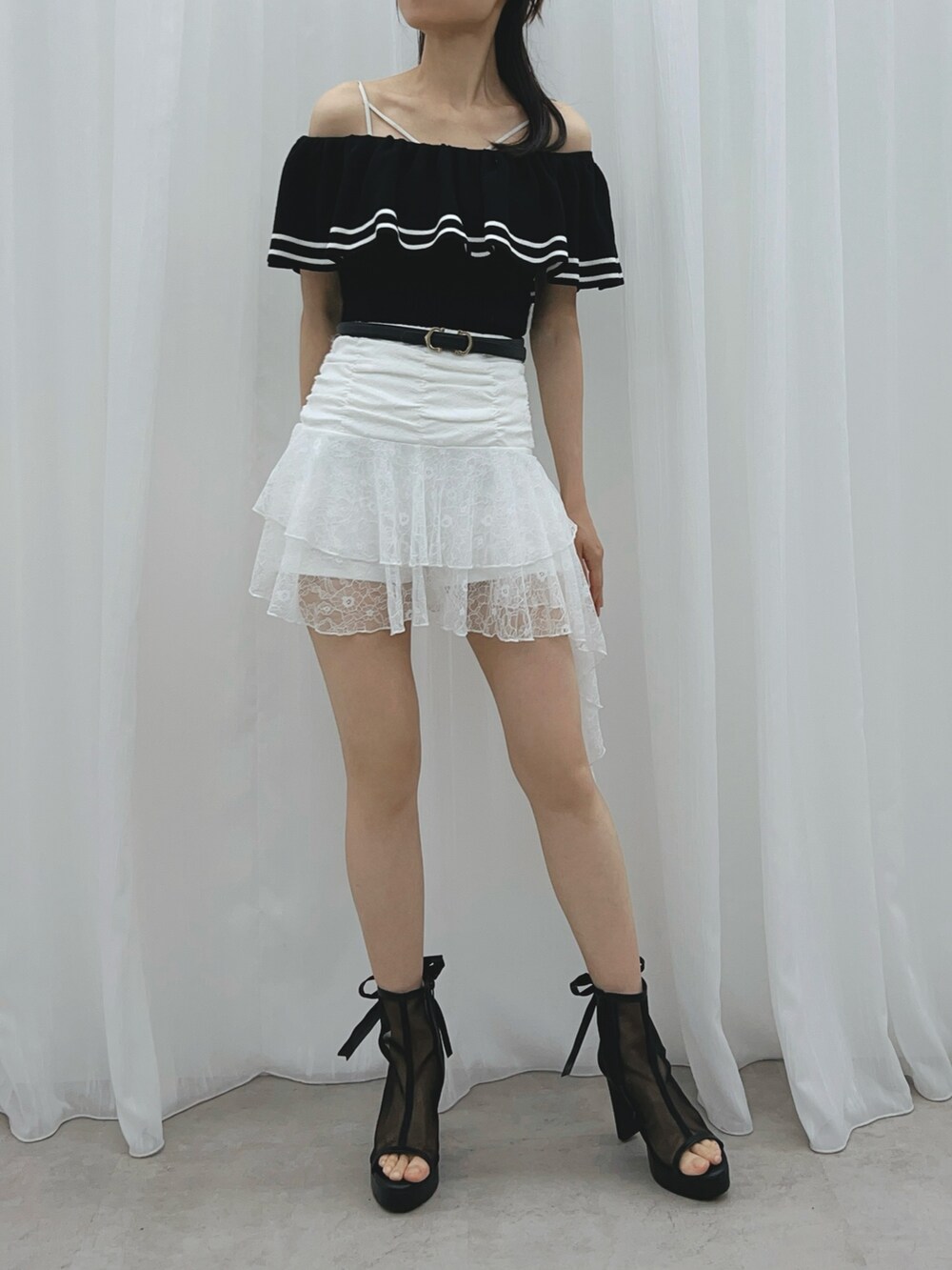 ブラック系のサンダル、ブラック系のニット/セーター、ホワイト系のスカートを着用したレディースの夏コーディネートの3枚目の写真