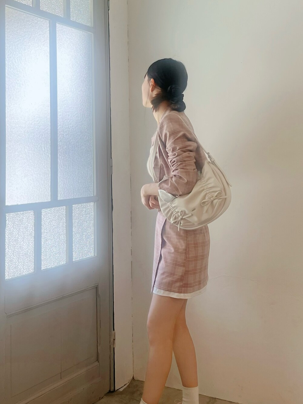 ピンク系のスカート、ホワイト系のショルダーバッグ、ピンク系のテーラードジャケットを着用したレディースの春コーディネートの5枚目の写真