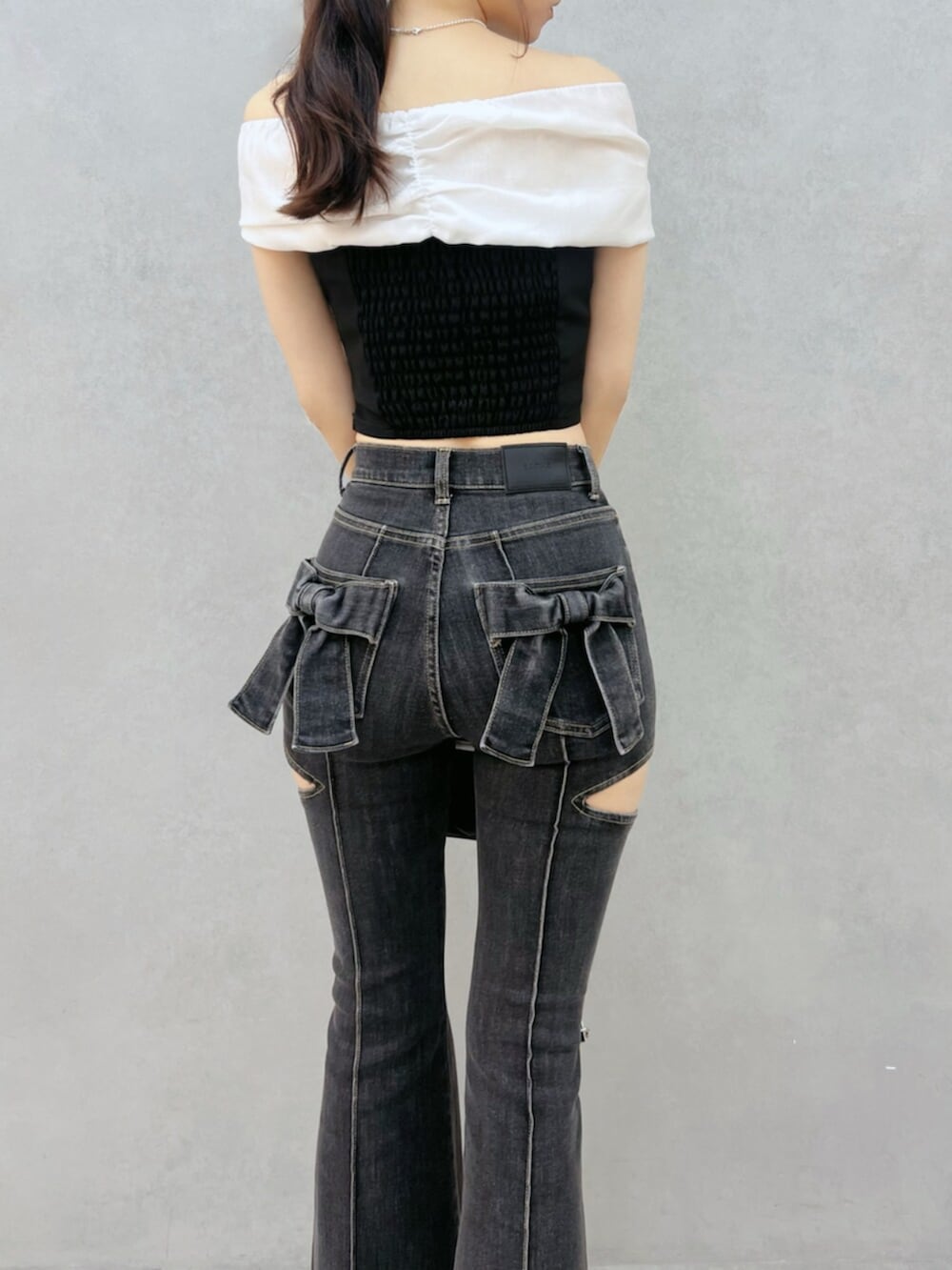 ブラック系のハンドバッグ、ブラック系のパンプス、ブラック系のデニムパンツを着用したレディースの夏コーディネートの6枚目の写真