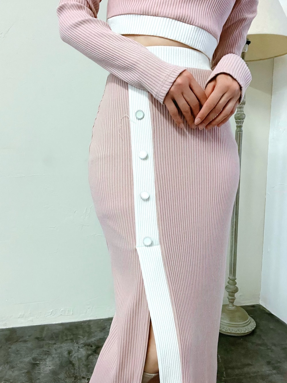 ピンク系のスカート、ピンク系のTシャツ/カットソー、ホワイト系のブーツを着用したレディースの冬コーディネートの6枚目の写真