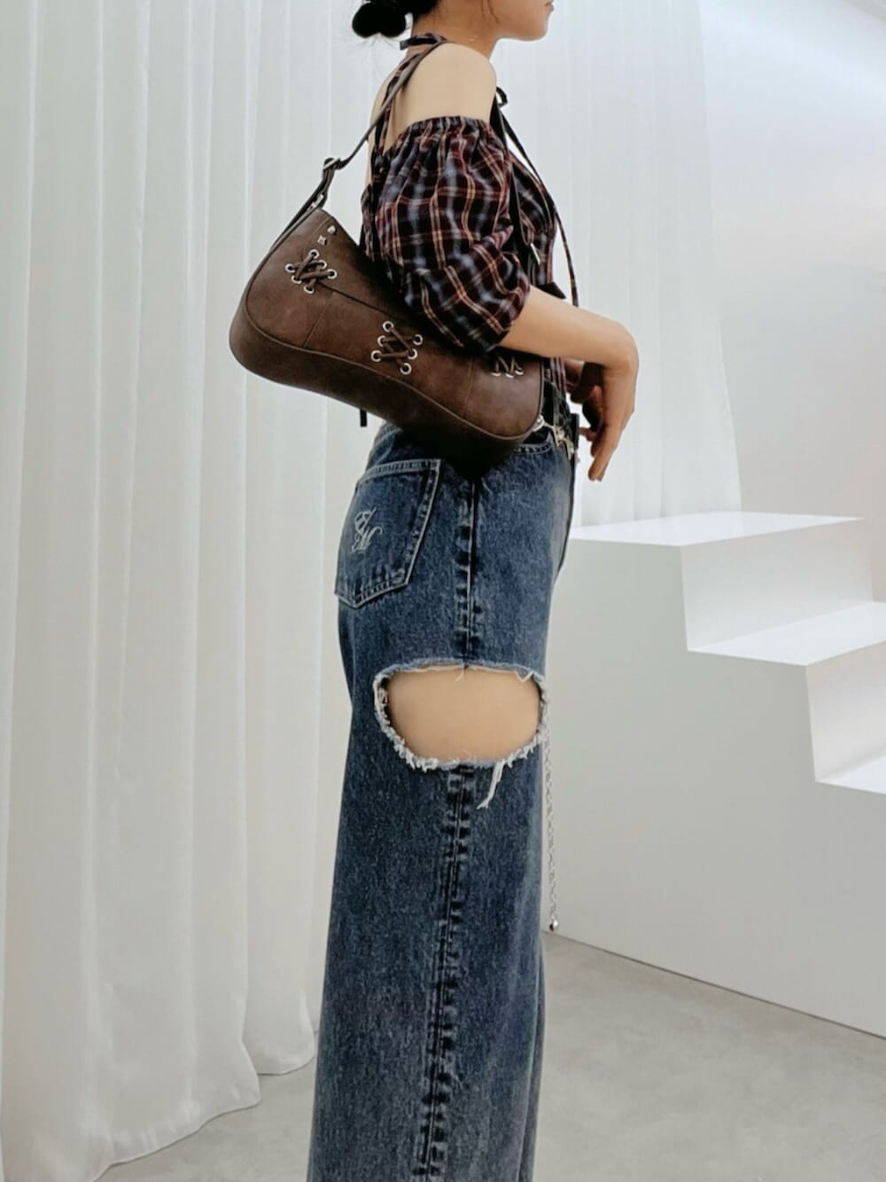 ブラウン系のショルダーバッグ、ブルー系のデニムパンツ、ブラウン系のサンダルを着用したレディースの秋コーディネートの5枚目の写真