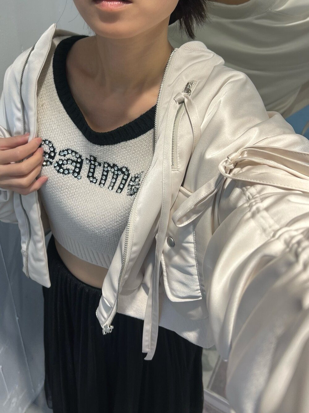 ホワイト系のニット/セーター、ホワイト系のブルゾンを着用したレディースの冬コーディネートの5枚目の写真