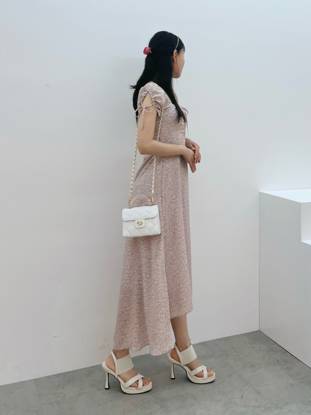 ピンク系のワンピース、ホワイト系のハンドバッグ、ホワイト系のサンダルを着用したレディースの春コーディネートの2枚目の写真