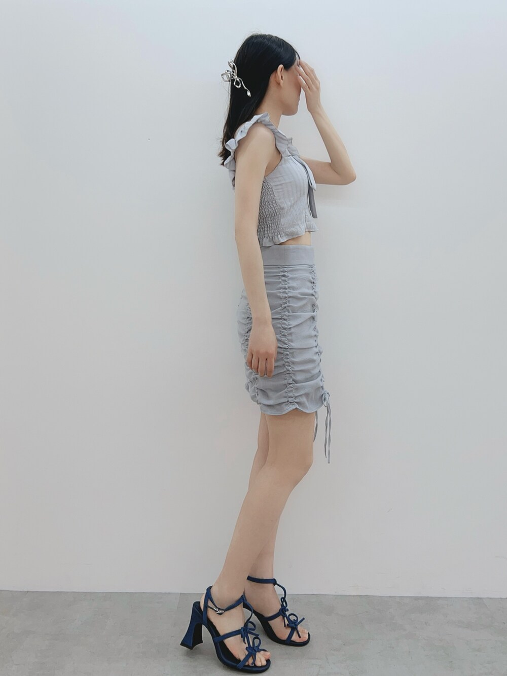 グレー系のシャツ/ブラウス、ブルー系のスカート、ブルー系のサンダルを着用したレディースの春コーディネートの4枚目の写真