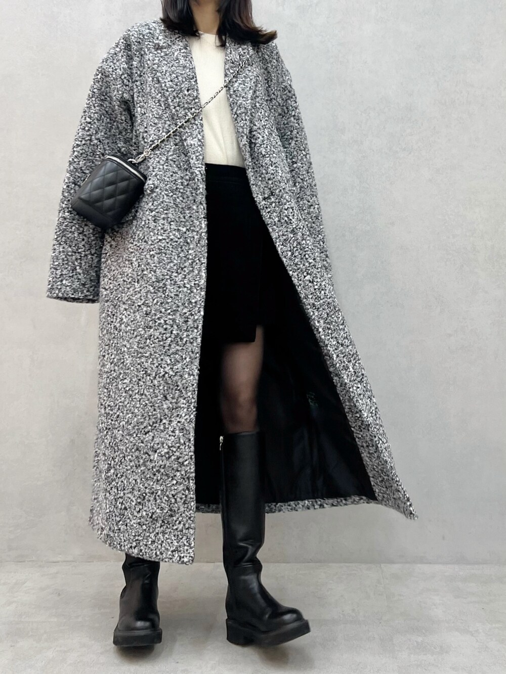 その他のチェスターコート、ブラック系のハンドバッグを着用したレディースの秋コーディネートの2枚目の写真