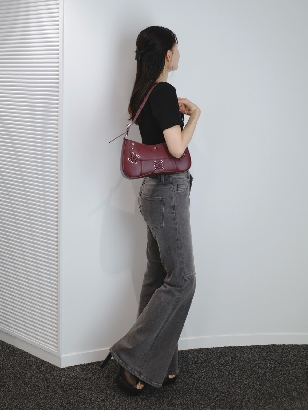 ブラック系のデニムパンツ、ブラック系のサンダル、レッド系のショルダーバッグを着用したレディースの夏コーディネートの2枚目の写真