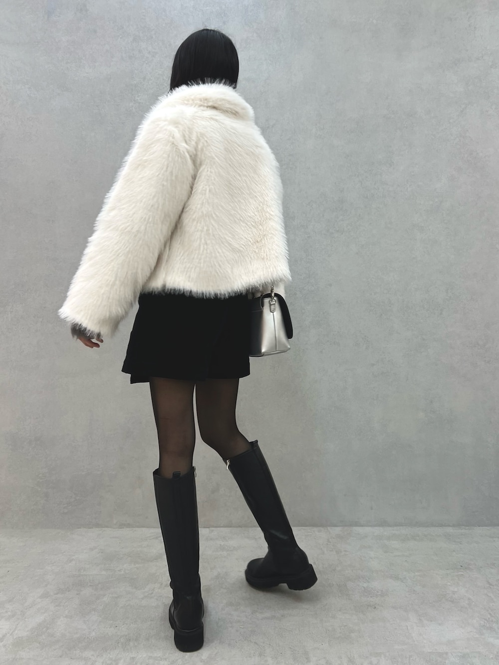 ホワイト系のその他アウター、グレー系のニット/セーター、シルバー系のショルダーバッグを着用したレディースの冬コーディネートの5枚目の写真