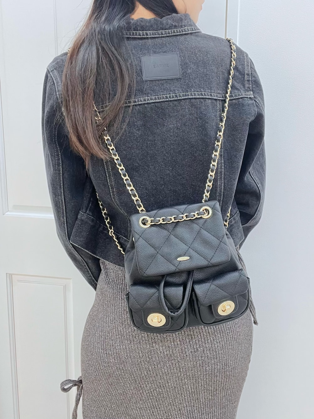 グレー系のワンピース、ブラック系のブーツ、ブラック系のデニムジャケットを着用したレディースの春コーディネートの6枚目の写真