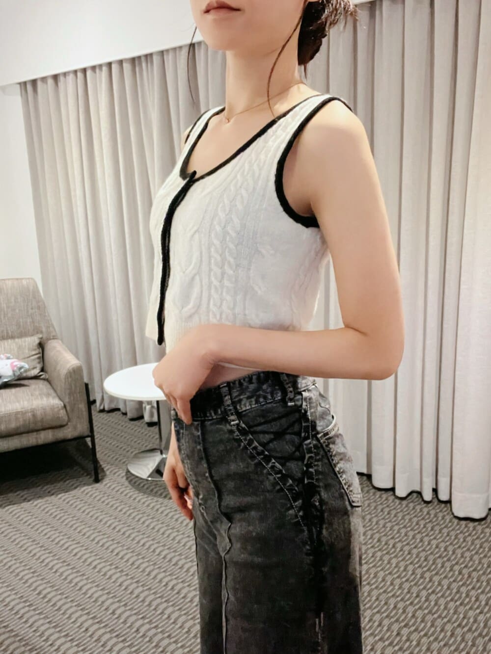 ホワイト系のニット/セーター、ブラック系のデニムパンツ、ゴールド系のネックレスを着用したレディースの秋コーディネートの9枚目の写真