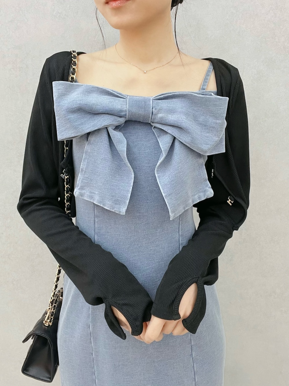 ブルー系のワンピース、ブラック系のTシャツ/カットソー、ブラック系のブーツを着用したレディースの春コーディネートの5枚目の写真