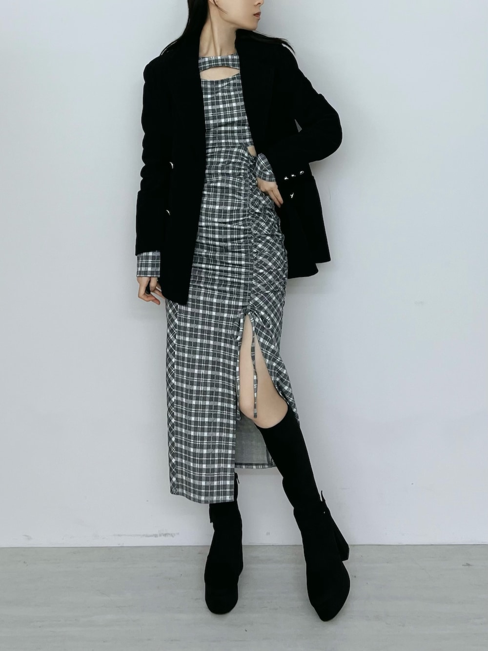 グレー系のワンピース、ブラック系のテーラードジャケット、ブラック系のブーツを着用したレディースの秋コーディネートの4枚目の写真