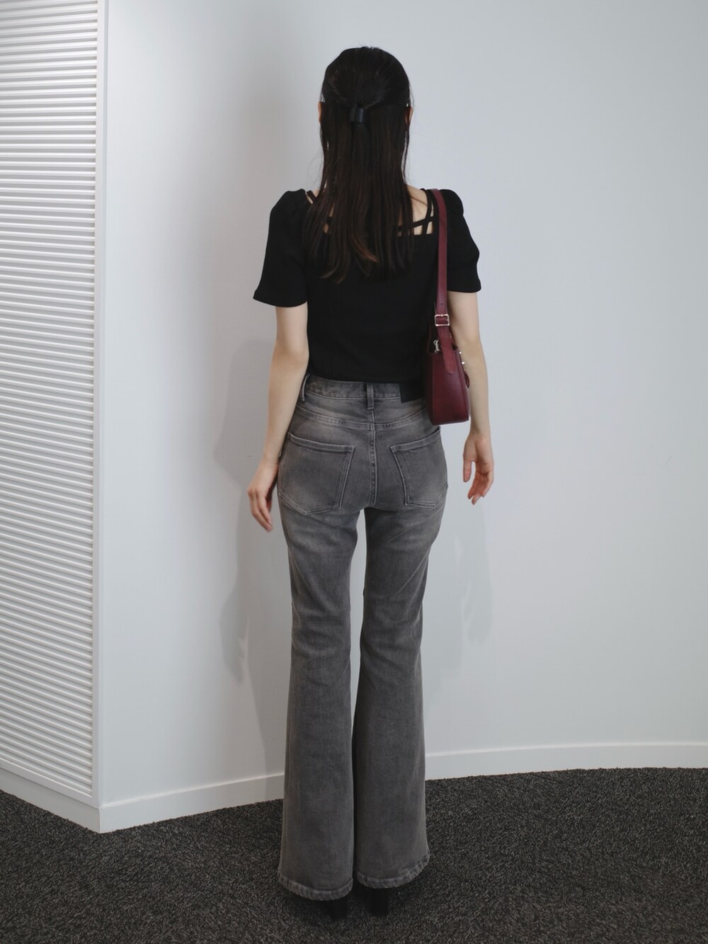 ブラック系のデニムパンツ、ブラック系のサンダル、レッド系のショルダーバッグを着用したレディースの夏コーディネートの3枚目の写真